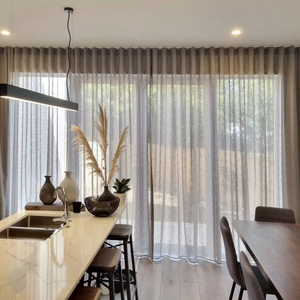 Flowing sheer curtain draping elegantly by window