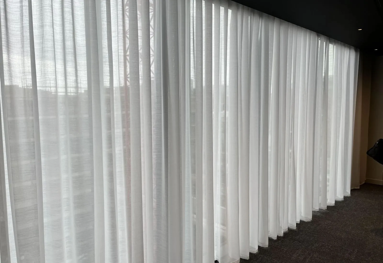 Soundproof sheer curtain installed in bright room